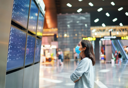 woman looking at flight schedule at airport