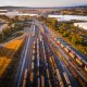 An overhead image of cargo trains on a railroad by a lake
